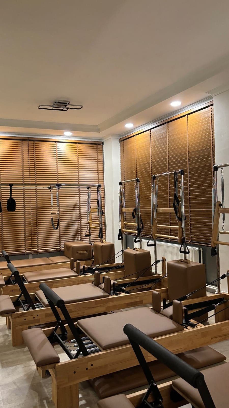 Base Pilates stüdyosunda yan yana dizilmiş reformer yatakları